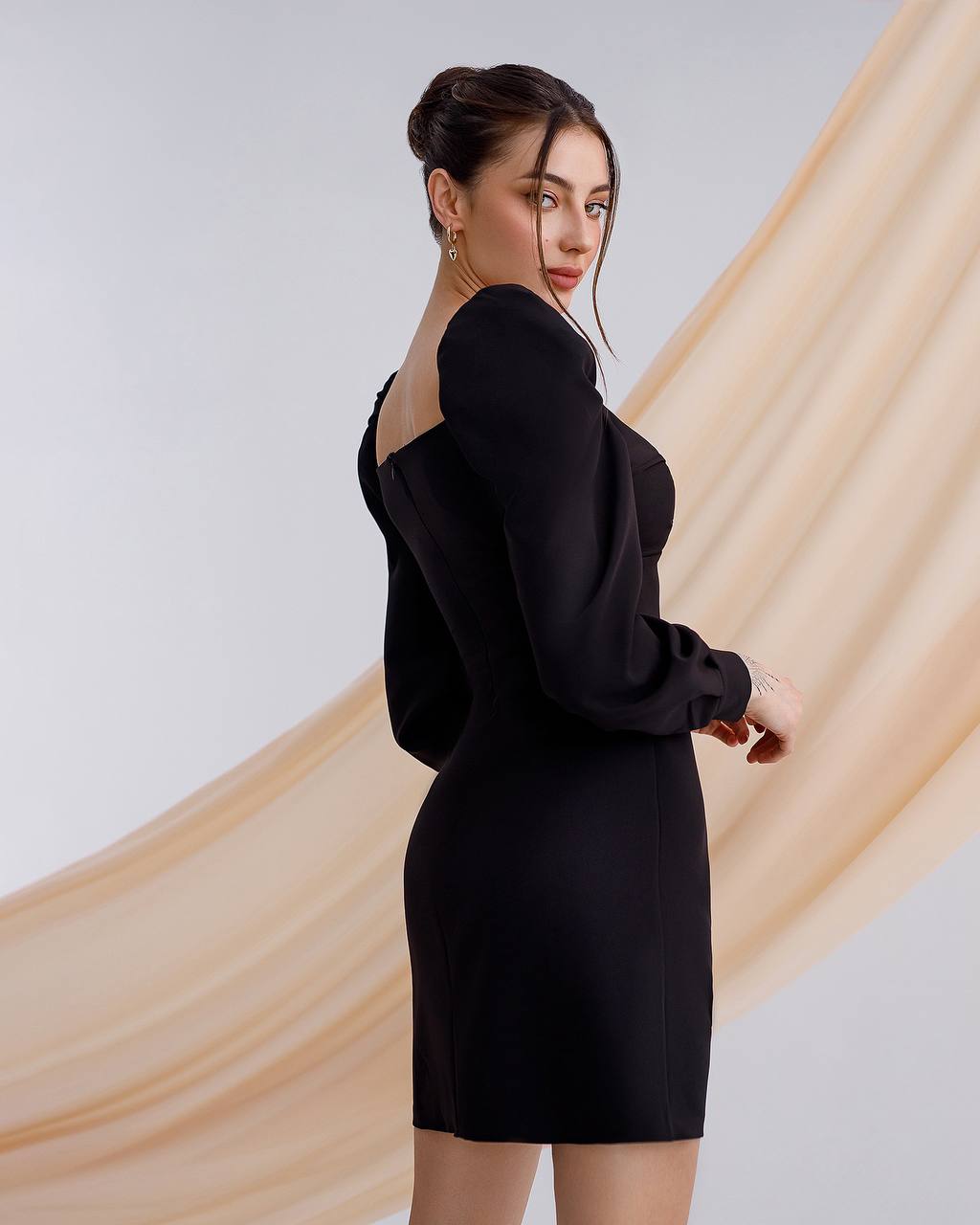 Woman wearing a black dress with a plain background