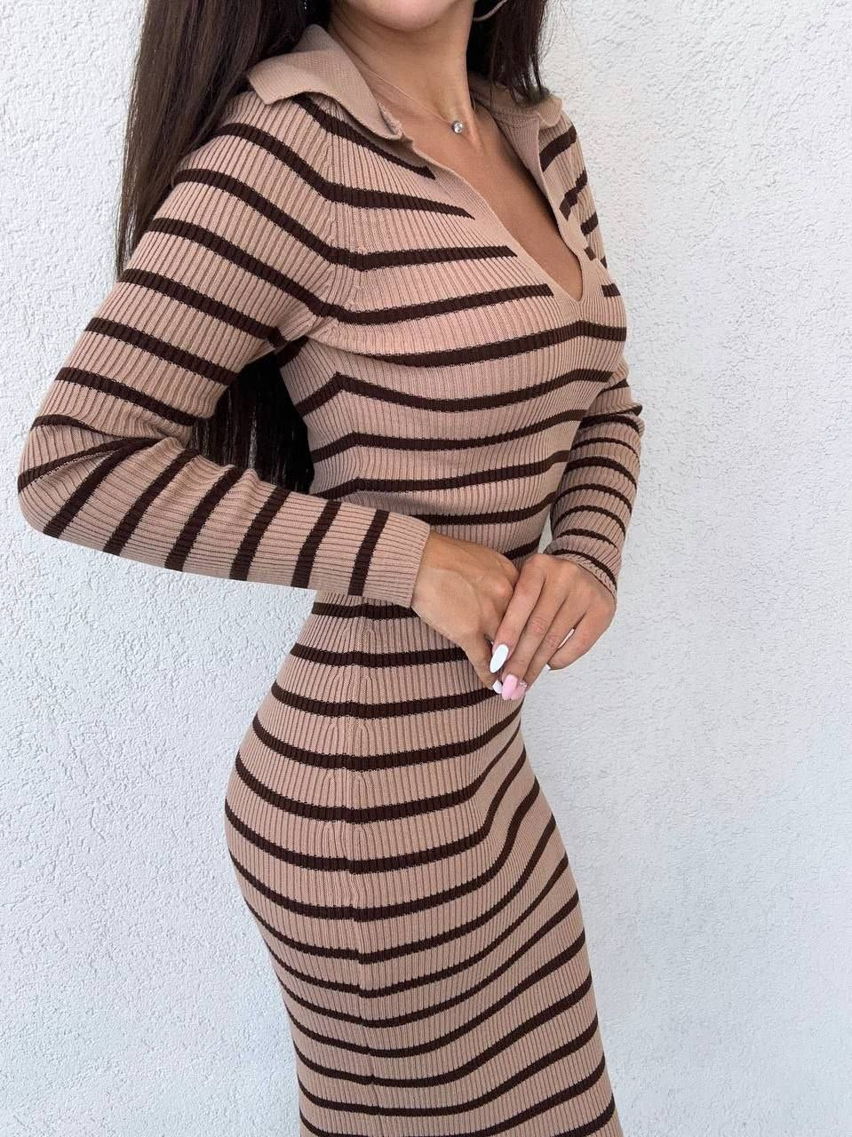 Woman wearing a brown and black striped dress against a white background