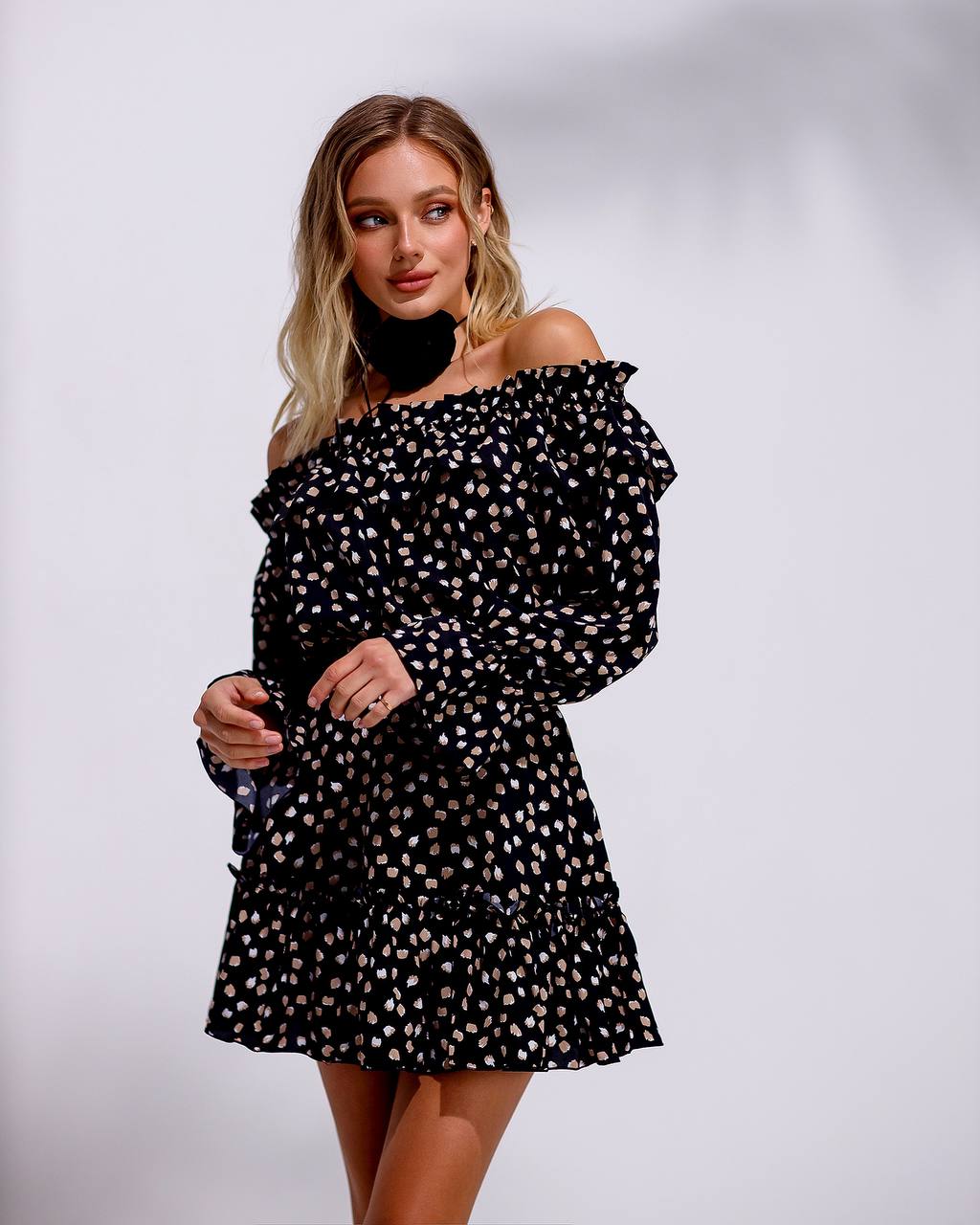 Woman wearing a black polka dot dress on a white background