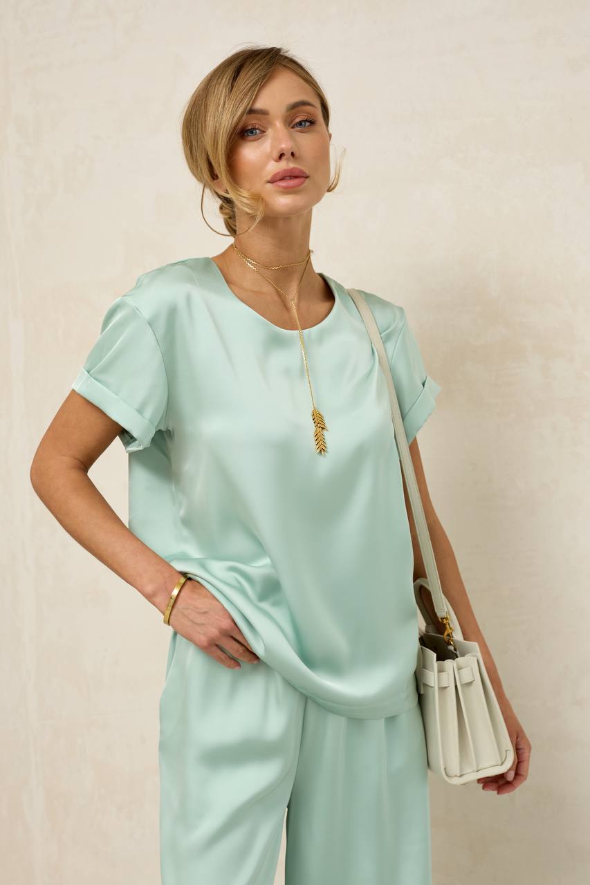 Woman wearing a light blue outfit with a beige background