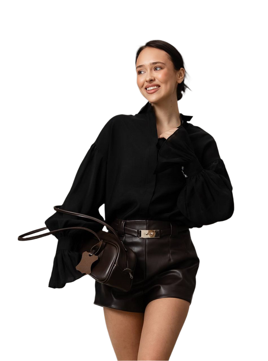 Woman wearing a black outfit with a leather handbag on a white background
