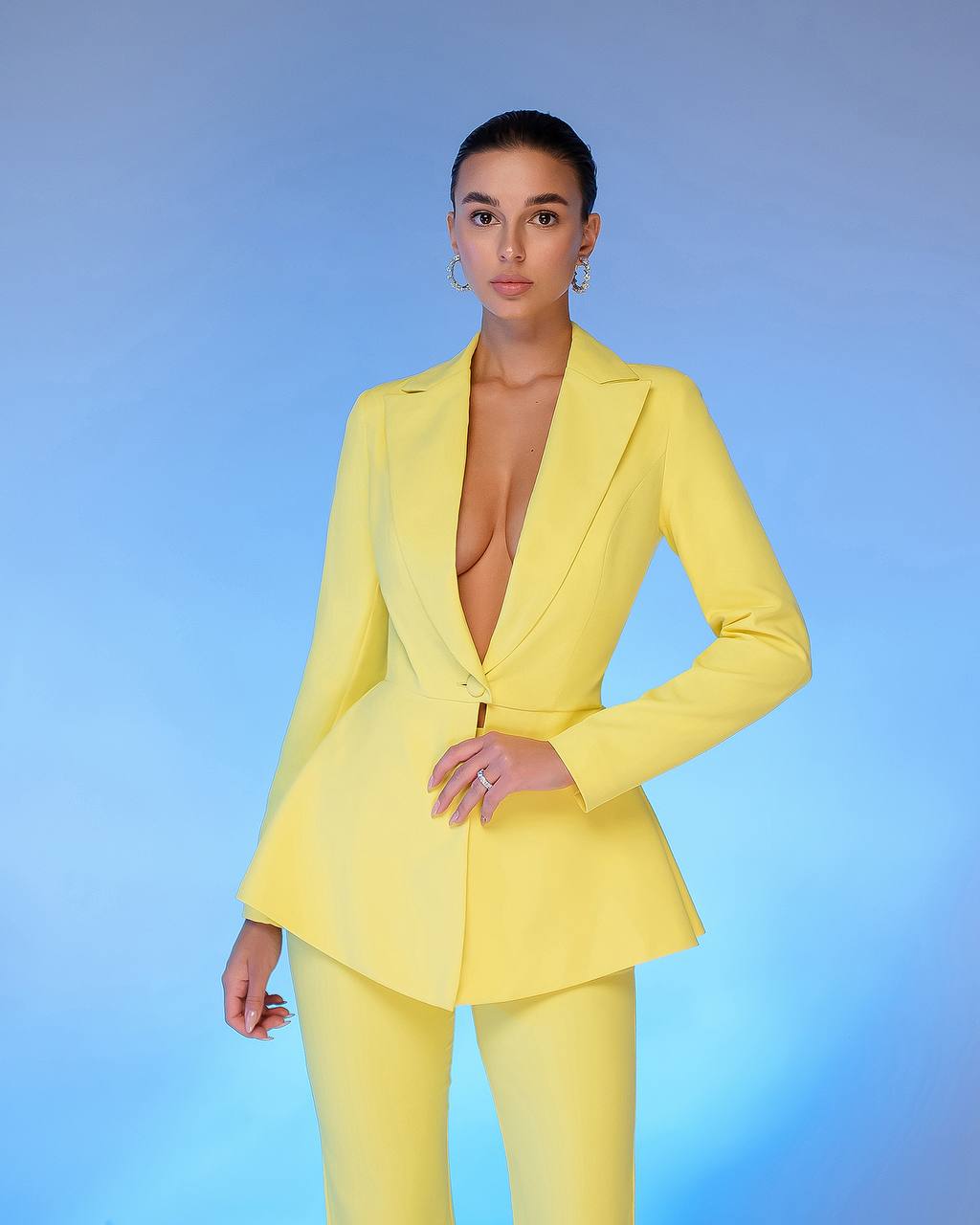 Person wearing a bright yellow suit against a blue gradient background