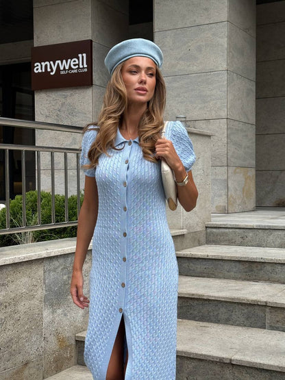 Woman in a light blue dress and hat standing outside a building with 'anywell' branding.