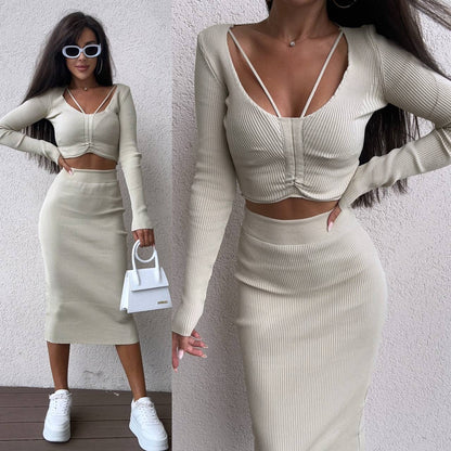 Woman wearing a beige long-sleeve top and skirt set with white sneakers and sunglasses.