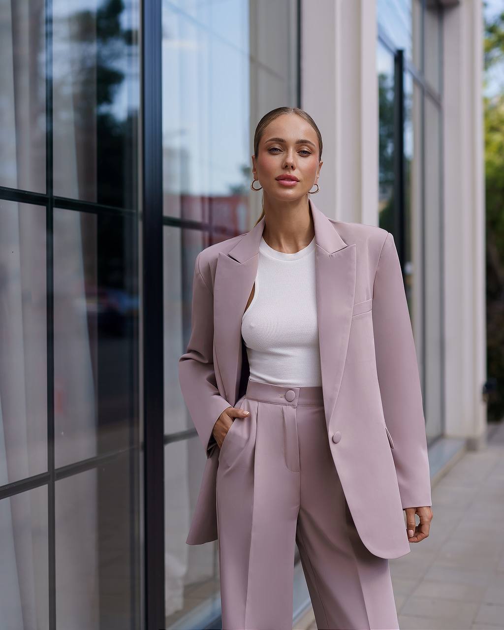 Woman in a pink suit standing in front of a building