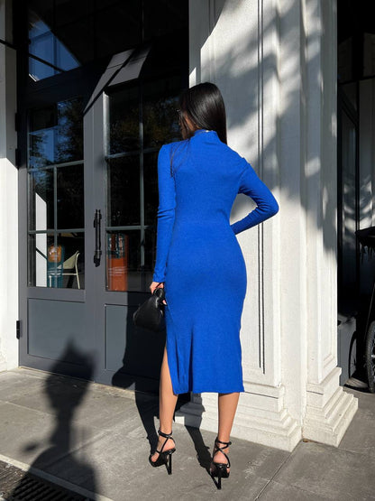 Woman in a blue dress standing outside a building