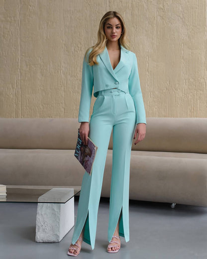 Woman in a light blue suit standing in a modern living room.