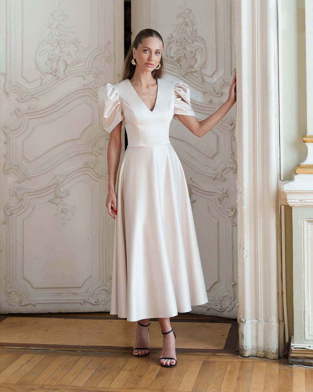 Woman in a white dress standing in an elegant interior setting