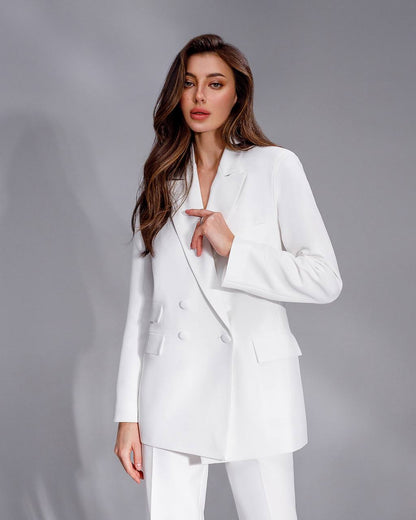 Woman wearing a white suit against a gray background