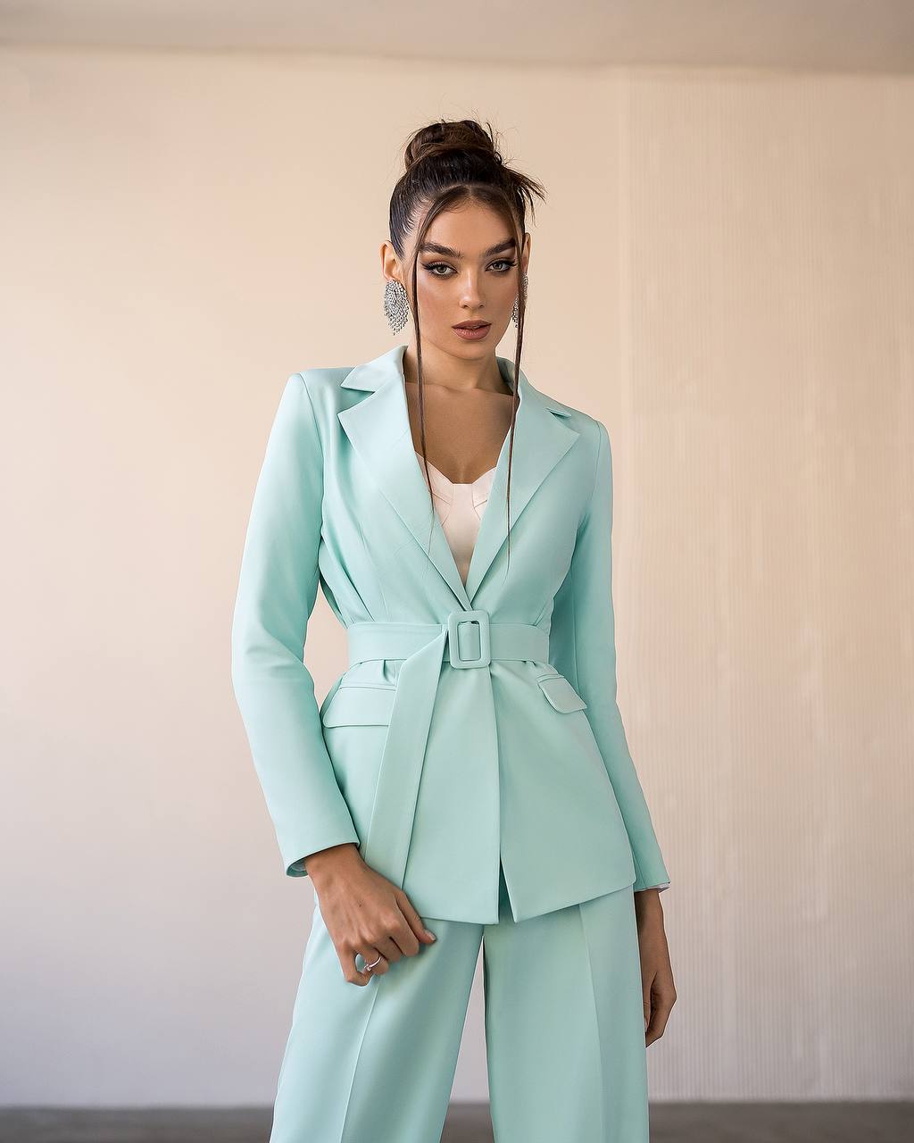 Woman wearing a light blue suit against a plain background
