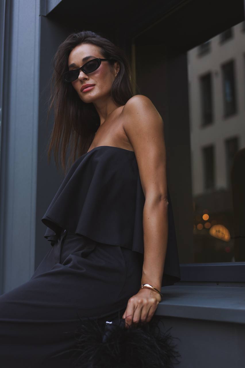 Woman wearing a black strapless top and skirt in an urban setting