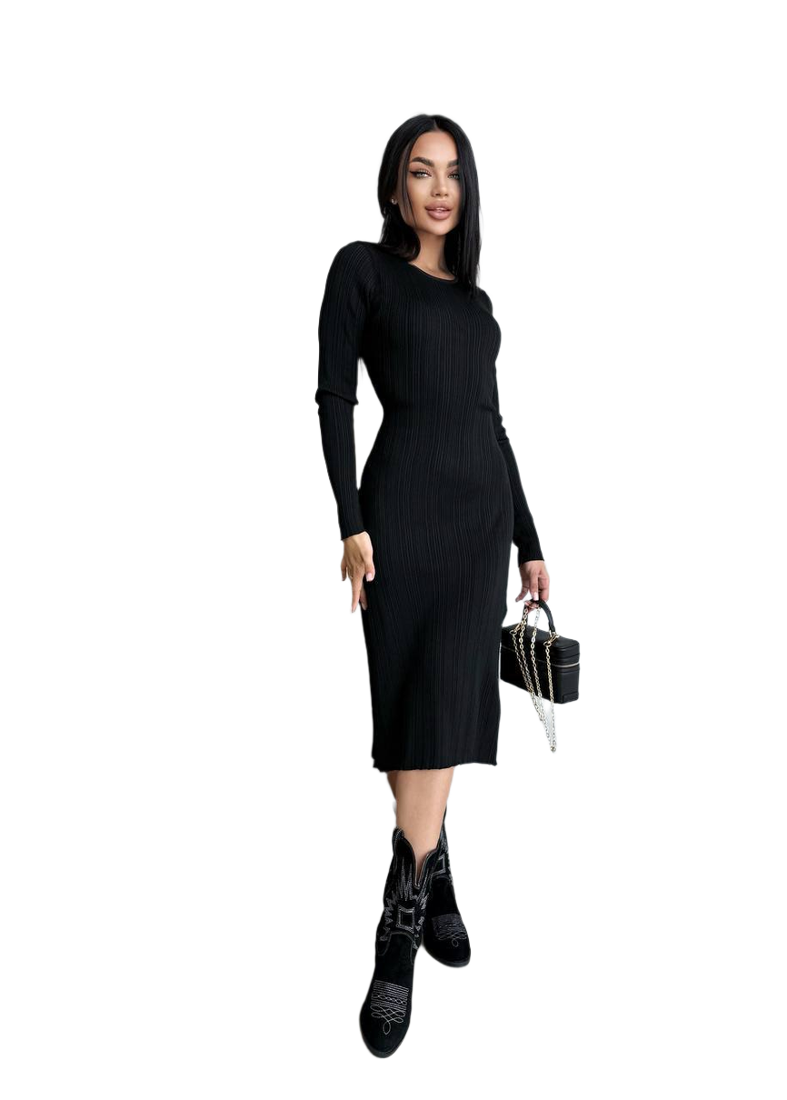 Woman wearing a black dress and black boots holding a black handbag on a white background