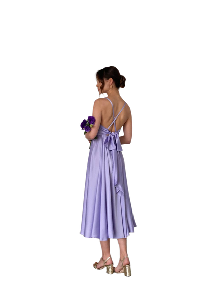Woman wearing a purple dress holding flowers on a white background