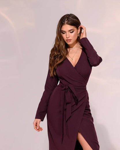 Woman wearing a burgundy wrap dress with a plain background