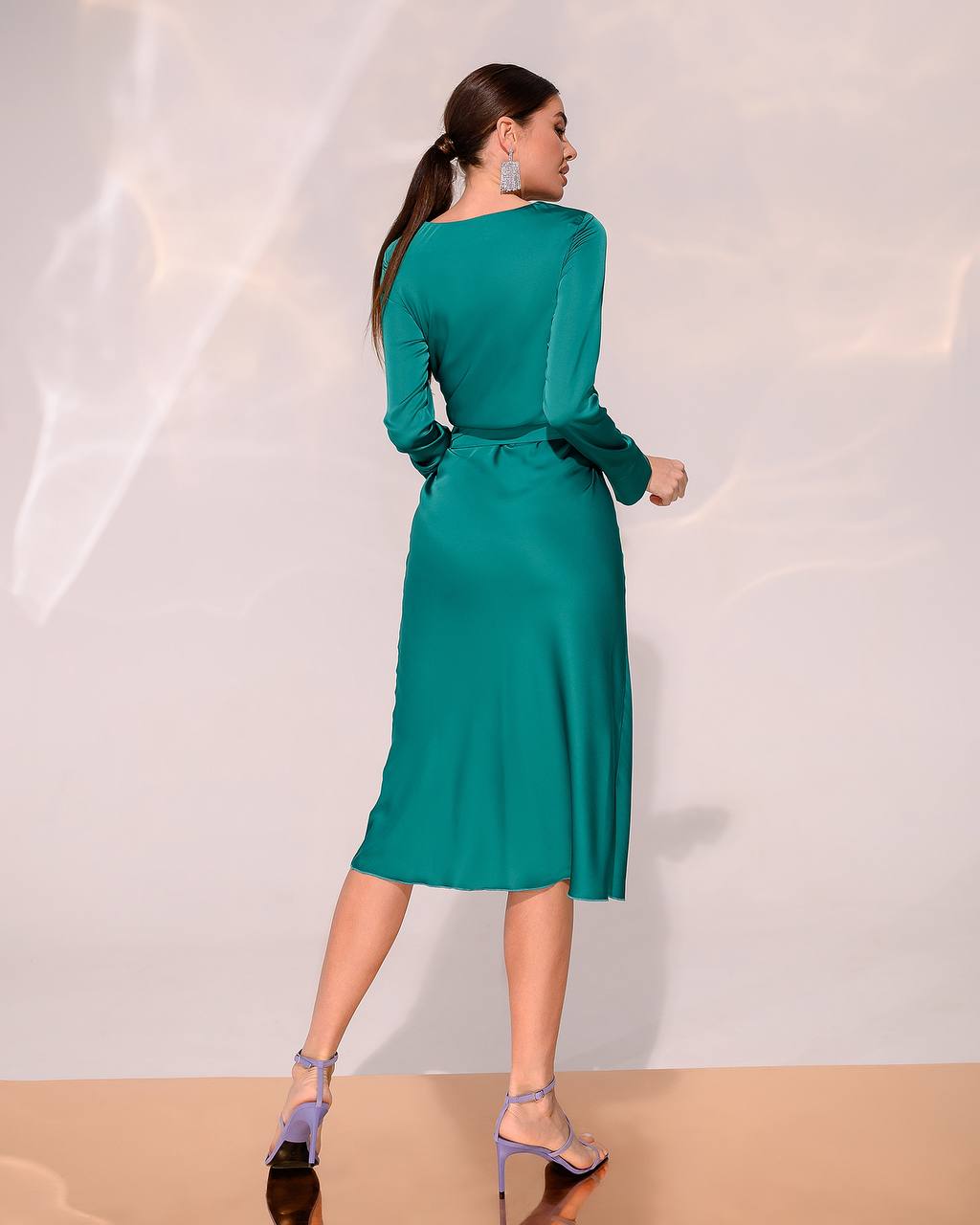 Woman wearing a green dress against a white background