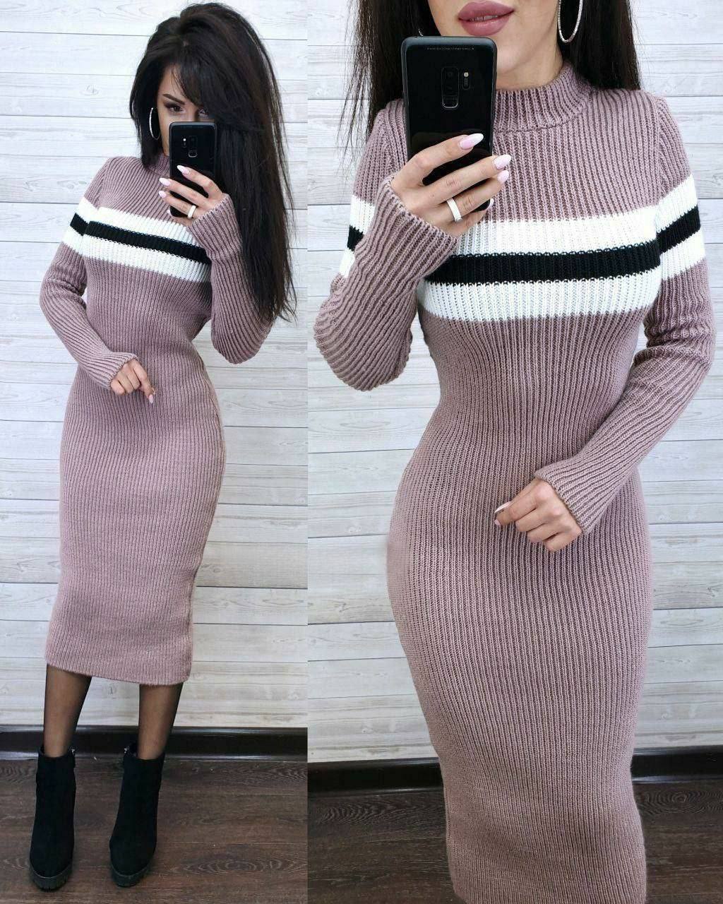 Woman wearing a ribbed knit dress with horizontal stripes, taking a mirror selfie.