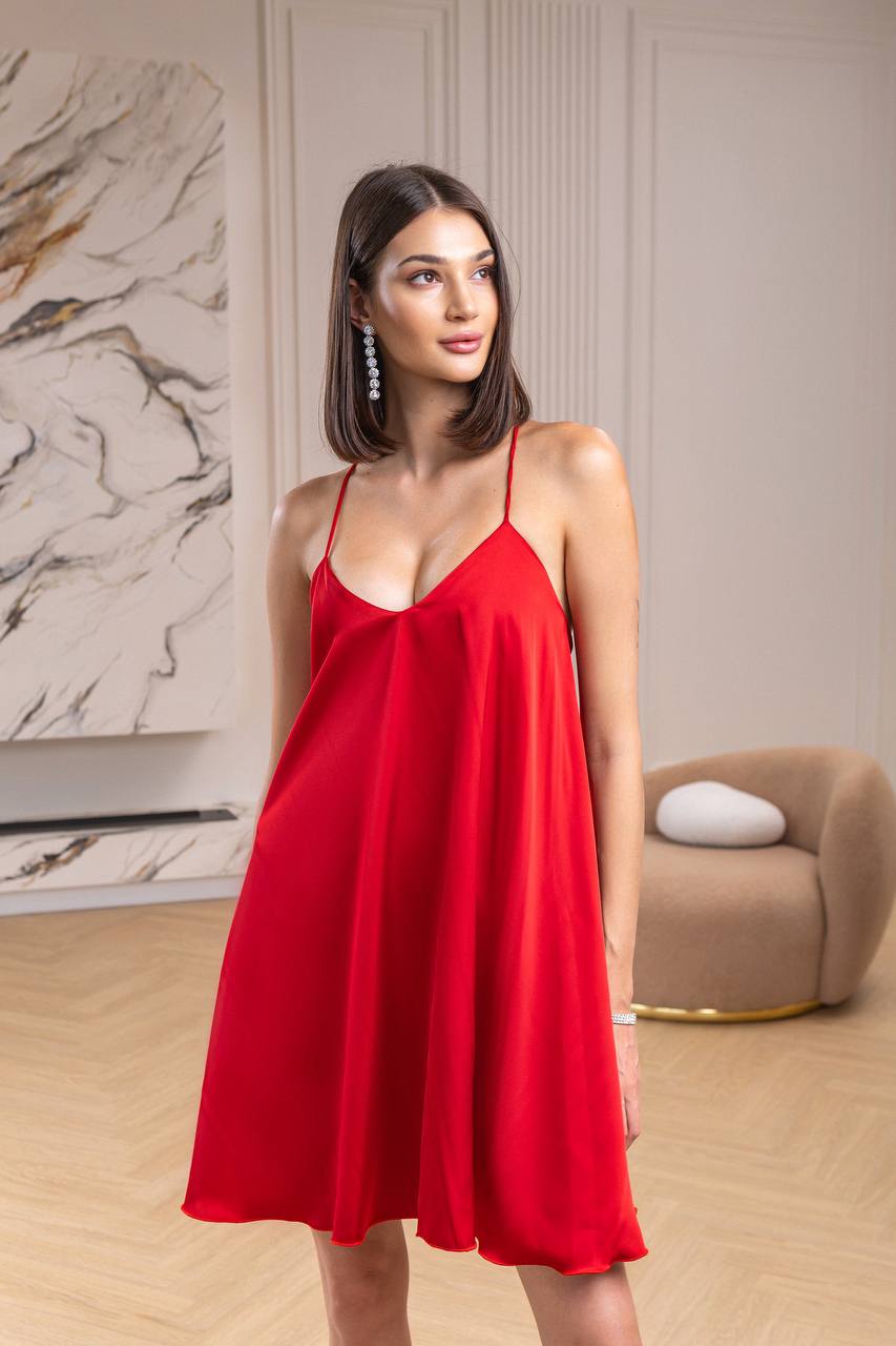Woman wearing a red dress in an indoor setting with a neutral background