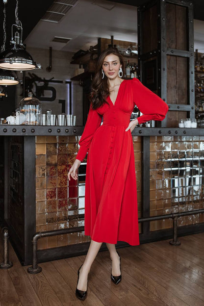 Woman in a red dress standing in a bar setting