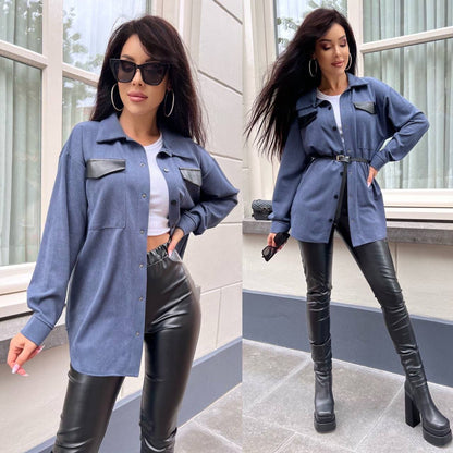 Woman wearing a blue jacket with black accents and black leather pants outdoors.