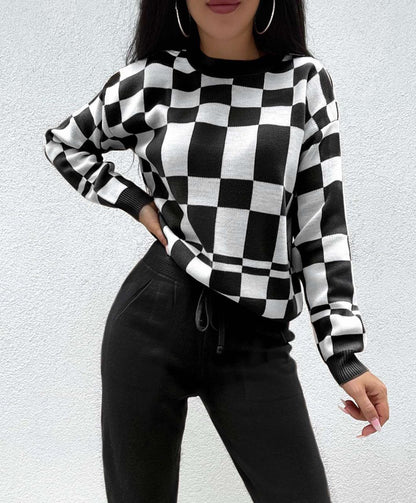 Person wearing a black and white checkered sweater against a light gray background