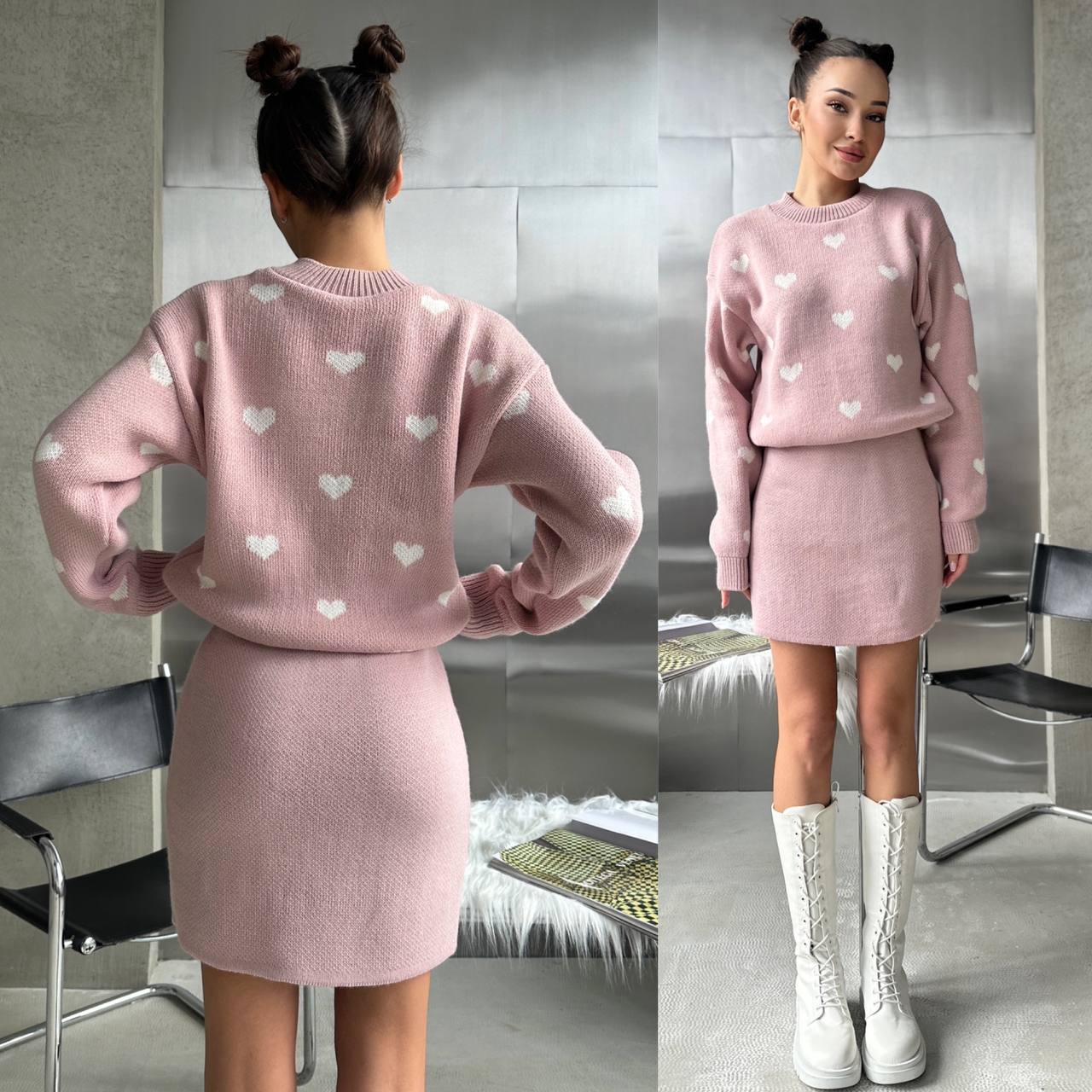 Woman wearing a pink sweater and skirt set with heart patterns, standing in a room.