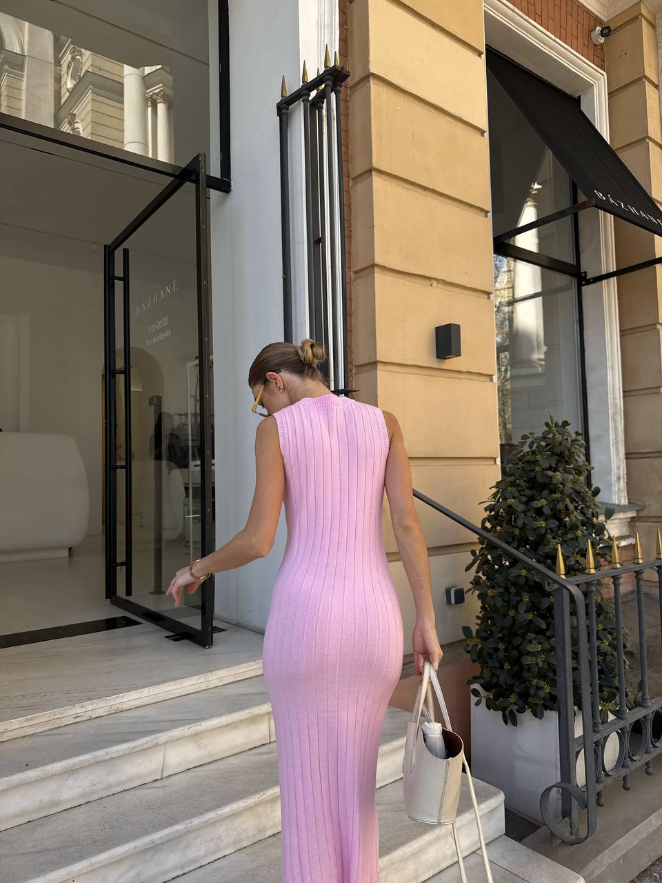 Woman in a pink dress walking out of a building
