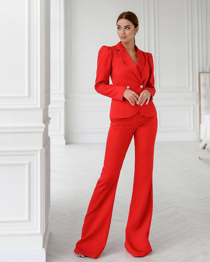 Woman wearing a red suit standing in a white room