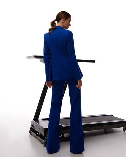 Person wearing a blue suit standing on a treadmill against a white background