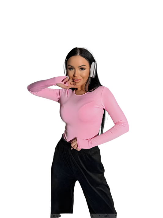 Woman wearing a pink long-sleeve top and black pants on a white background
