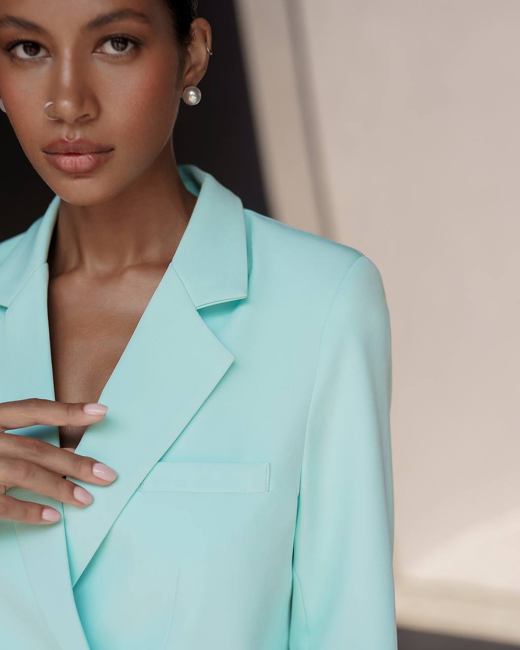 Woman wearing a light blue blazer against a neutral background