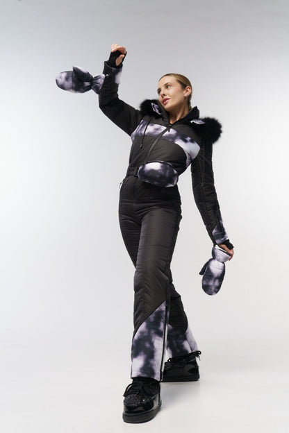 Person wearing a black and gray outfit with fur-lined hood on a white background