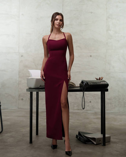 Woman in a burgundy dress standing in an office setting.