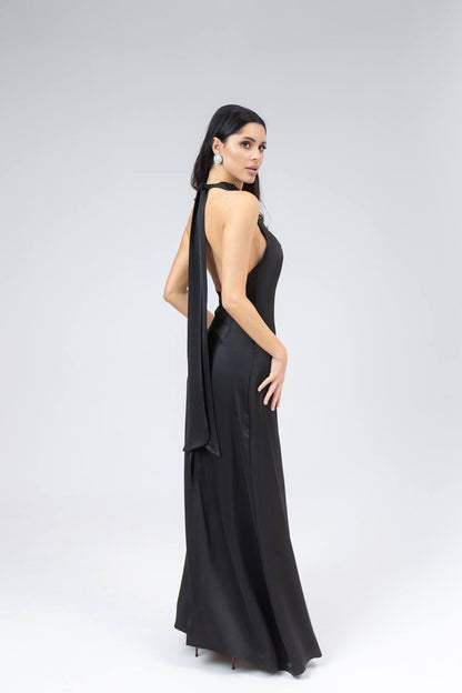 Woman wearing a black evening gown with a draped effect on a white background