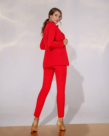 Woman wearing a red suit with gold shoes on a white background