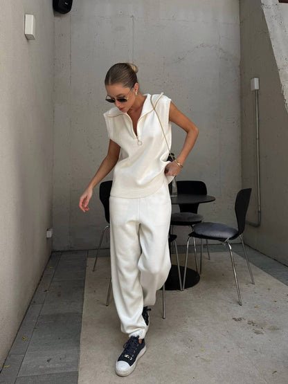 Person wearing a white outfit with black sneakers in an indoor setting