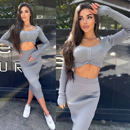 Woman wearing a gray outfit with cut-out design in front of a building.