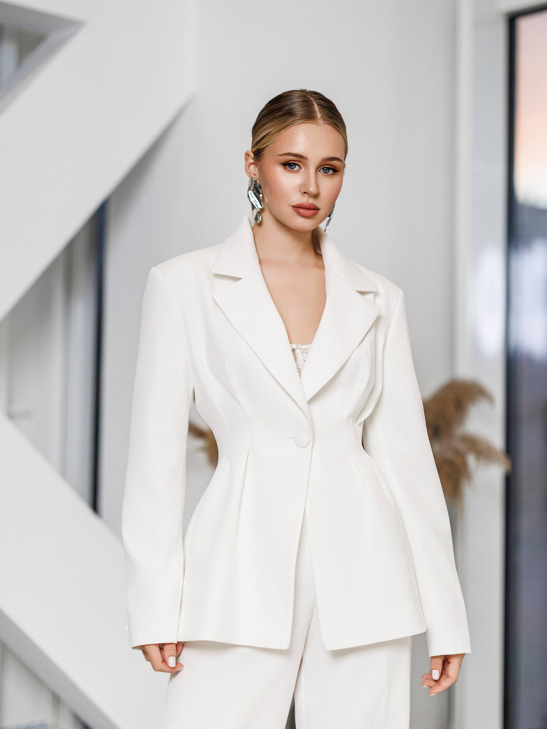 Woman wearing a white blazer in an indoor setting