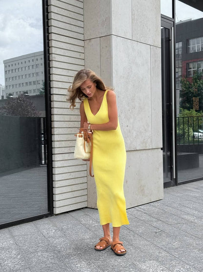 Woman in a yellow dress standing outside a building