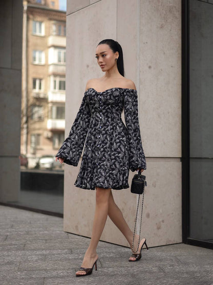 Woman in a floral off-shoulder dress walking on a city street.