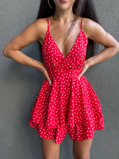 Woman wearing a red polka dot dress against a gray background