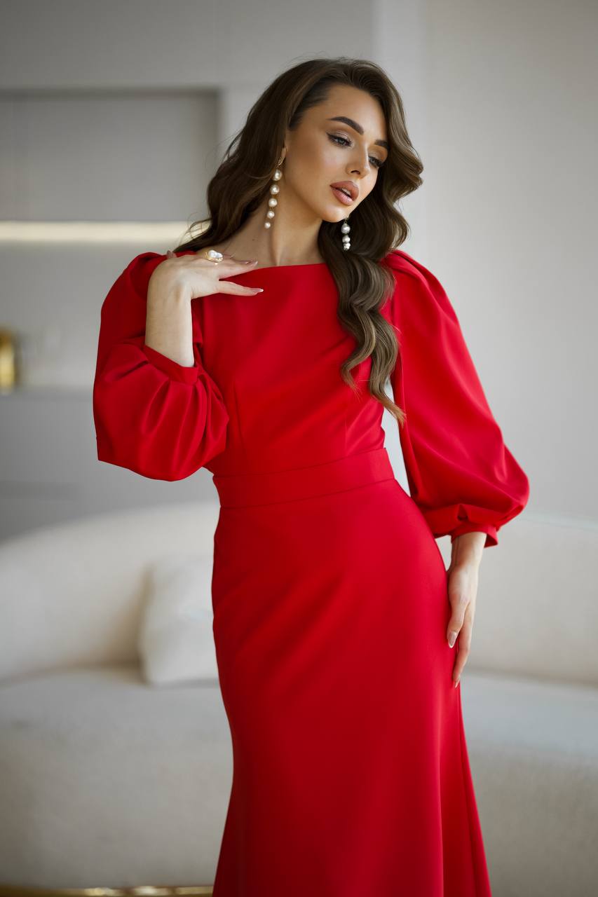 Woman wearing a red dress with puffed sleeves in an indoor setting