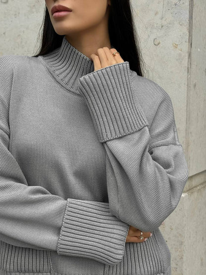 Gray ribbed sweater worn by a person against a neutral background