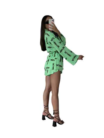 Person wearing a bright green outfit with text pattern on a white background