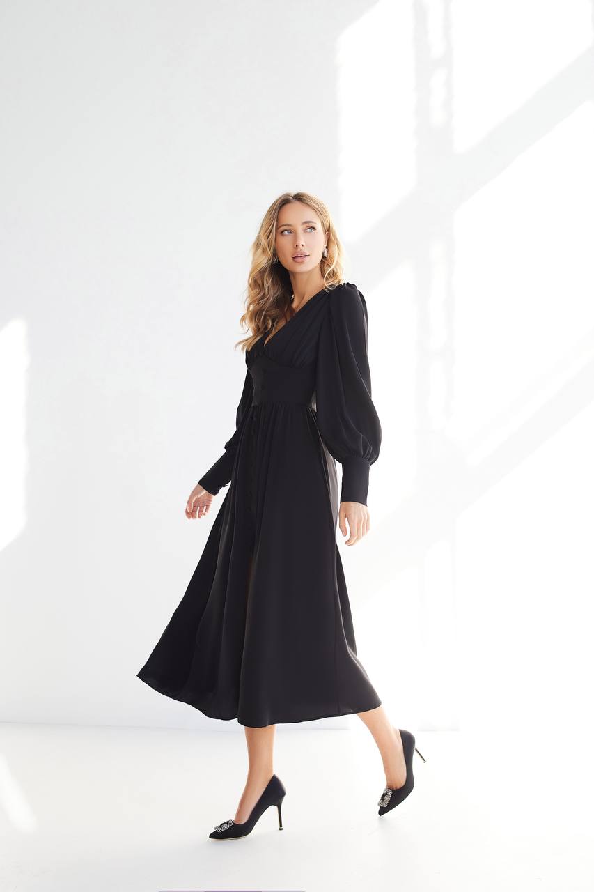 Woman wearing a black dress against a white background