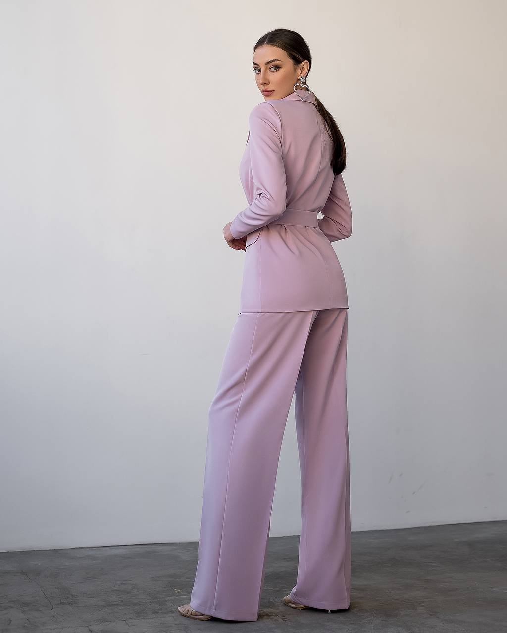 Woman wearing a pink outfit against a plain background