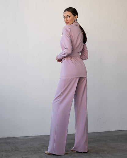 Woman wearing a pink outfit against a plain background
