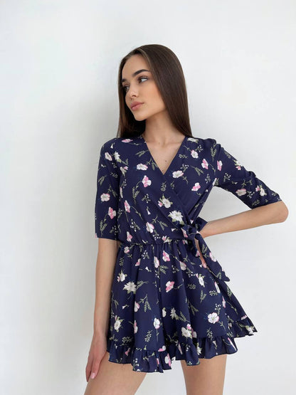 Woman wearing a navy floral dress against a white background