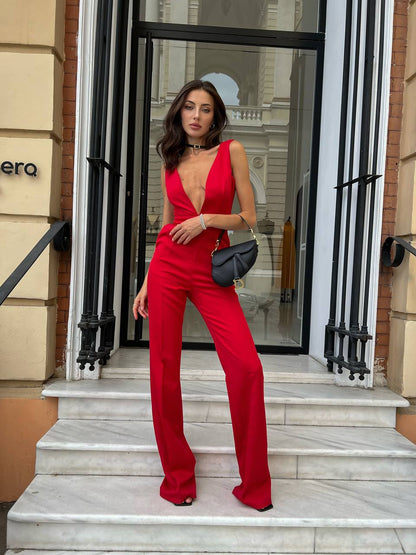 Woman in a red jumpsuit standing on steps outside a building