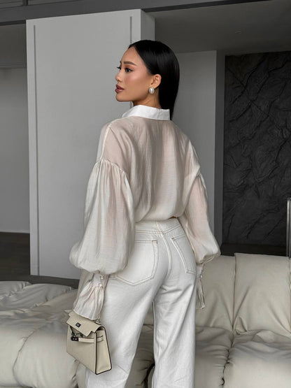 Woman in a stylish outfit with a neutral color palette in an indoor setting.