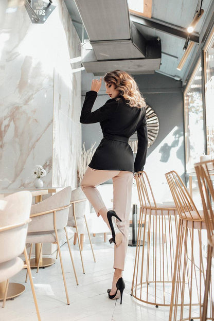 Woman in a stylish outfit standing in a modern restaurant.